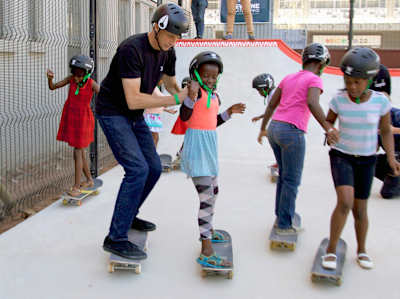 Tony Hawk ajudando os alunos na abertura da escola e skatepark da Skateistan em Johannesburgo