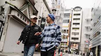 Shigekix and Ronnie walk along the street in Tokyo, Japan, during filming for Breaking Beyond, a show about breaking and hip-hop on Red Bull TV.