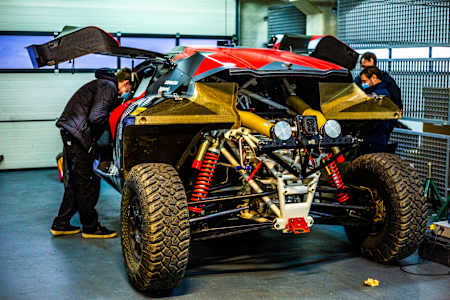 Technicians work on the Odyssey 21 Extreme E race vehicle.