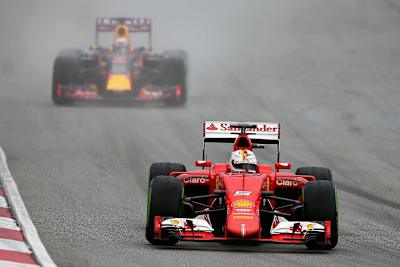 Sebastian Vettel of Germany and Ferrari drives ahead of Daniel Ricciardo of Australia and Infiniti Red Bull Racing during qualifying for the Malaysia Formula On