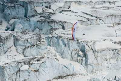 Sunning scenery of a paraglider flying over the glacier.