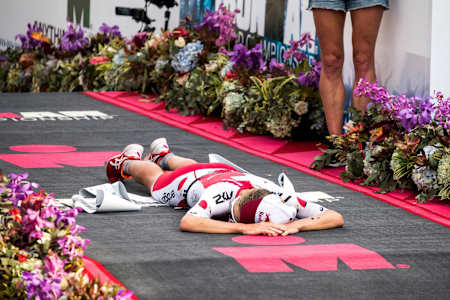 Daniela Ryf collapses with relief for her incredible accomplishment of winning three IRONMAN World Championship in a row.