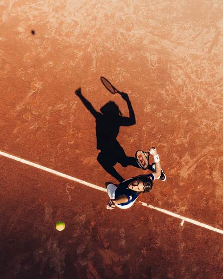 An image of Greece's Stefanos Tsitsipas serving on a clay court.