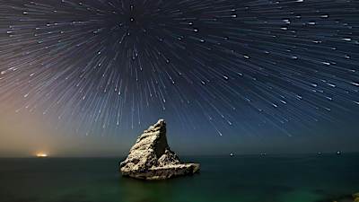 Calm see but the stars in the sky are moving.