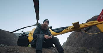 Brage Vestavik sits beside a yellow Red Bull helicopter in the Chilean mountains.