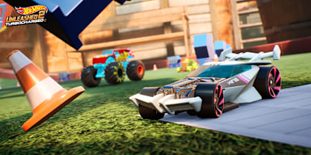 Screenshot aus Hot Wheels Unleashed 2 zeigt einen Sportwagen beim Drift und einen Monstertruck im Hintergrund.