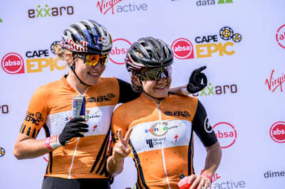 Laura Stigger and Sina Frei pose for celebratory photos at the end of the 2021 Absa Cape Epic.