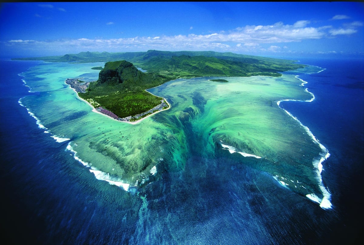 Sand flows out of a lagoon into an ocean