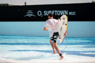 Profi-Surfer Leon Glatzer läuft nach einer Welle in der o2 SURFTOWN MUC, dem Wavepool in Hallbergmoos zurück zum Peak.