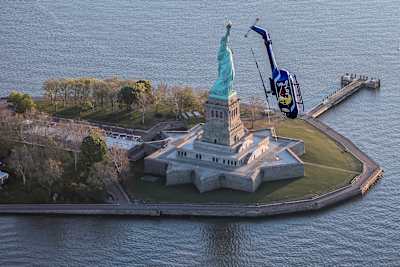 Red Bull Aerobatic Helicopter Pilot, Aaron Fitzgerald, performs flips, barrel rolls and nose dives in front of the Statue of Liberty during the morning hours on May 18, 2019.