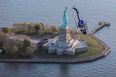 Red Bull Aerobatic Helikopter -Pilot, Aaron Fitzgerald, zeigte in den frühen Morgenstunden des 18. Mai 2019 spektakuläre Flips, Barrel Rolls und Nose Dives vor der berühmten Freiheitsstatue.