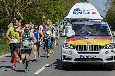 Teilnehmer beim Wings for Life World Run in  München werden vom Catcher Car überholt.