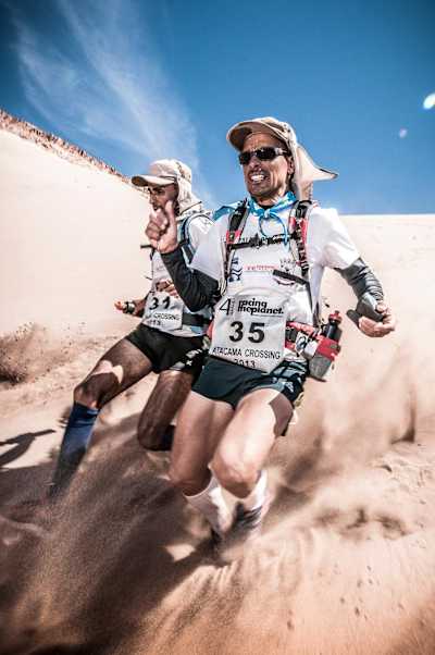 Participants descend a dune in the The Atacama Crossing