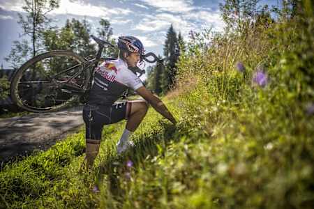 Szymon Godziek carries his bike during his backflip over the Tour de Pologne cycling race attempt on August 4, 2017