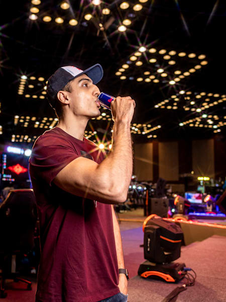 Indian gamer Ankit 'V3nom' Panth drinks a can of Red Bull at an event.
