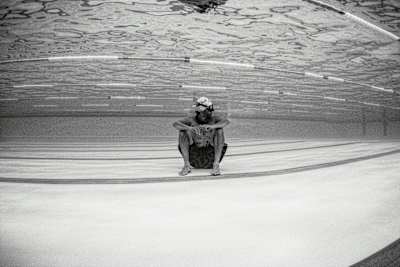 Swimmer sits at the bottom of a pool.