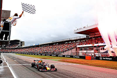 A photo of Max Verstappen crossing the finish line during a Formula One race.