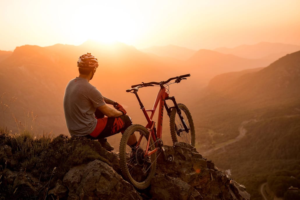Um ciclista desfruta do pôr do sol.