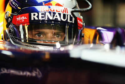 Et foto af en fokuseret Sebastian Vettel med hjelm på, i sin Formel 1 bil.