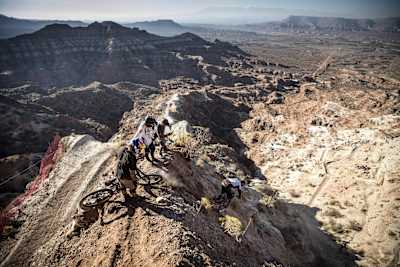 Riders watch Vincent Tupin drop in on a steep chute at Red Bull Rampage 2017.