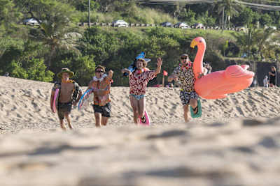 Un grupo con camisas hawaianas y un flamenco de plástico.