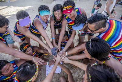 Un grupo une sus manos en la playa.