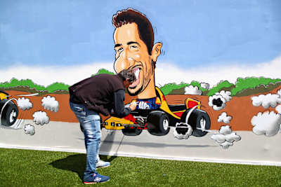 An artist paints a Daniel Ricciardo of Australia and Red Bull Racing mural in the fan area during the Spanish Formula One Grand Prix at Circuit de Catalunya on May 13, 2018 in Montmelo, Spain.