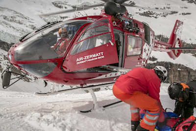 Air Zermatt pilot, Sam Summermatter waits patiently as his rescue team prepares the patient for flight