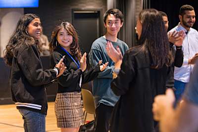 Nandhika Venkateswaran of EnergyBrid interacts with other finalists at the Red Bull Basement University World Finals in Toronto.