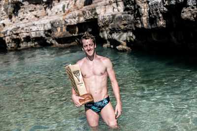 Le plongeur britannique Gary Hunt pose avec avec le fameux trophée King Kahekili après avoir remporté les Red Bull Cliff Diving World Series 2018 à Polignano a Mare en Italie.
