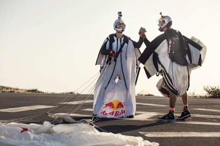 Zwei Wingsuit-Piloten freuen sich nach erfolgreich absolviertem Flug.
