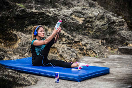 woman stretching on a mat at the beach