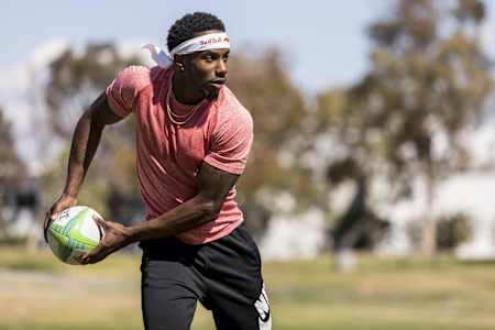 Le joueur de rugby Carlin Isles se prépare à passer le ballon lors d'un entrainement.