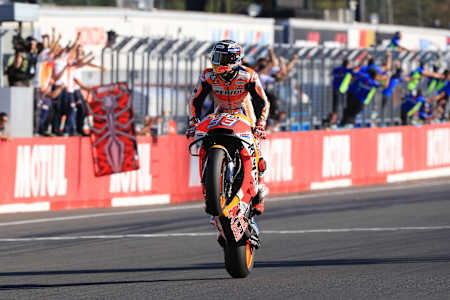 A photo of Marc Márquez standing on his moving bike after winning the 2018 Japan MotoGP.