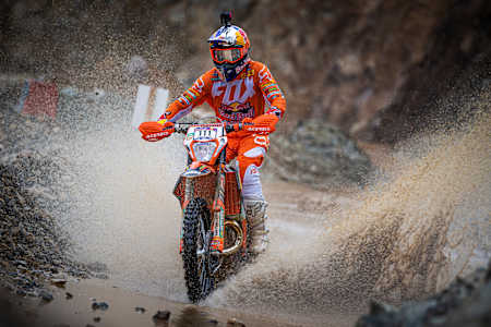 Taddy Błażusiak w goglach Scott przejeżdża przez wodę