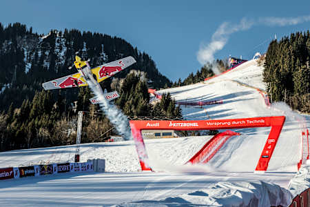 Dario Costa fliegt mit dem Red Bull Stunt-Flugzeug durch den Zielbogen der Streif in Kitzbühel, Österreich.