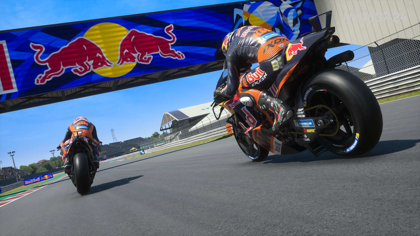 Una schermata di MotoGP 24 mostra Jack Miller e Brad Binder sotto lo striscione Red Bull a Misano.