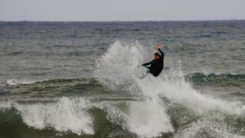 A surfer rides the waves in Italy.