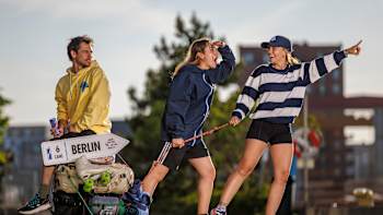 Three young people, one holding a Berlin sign, having fun and celebrating during the Red Bull Can You Make It event in Malmoe, Sweden