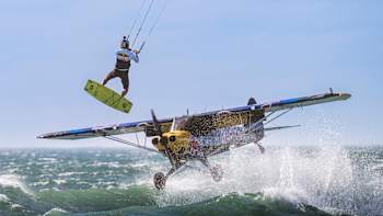 Lasse Walker of the Netherlands jumps over a CubCrafters Carbon Cub airplane piloted by Luke Czepiela of Poland on Dolphin Beach in Cape Town, South Africa on January 16, 2025. 