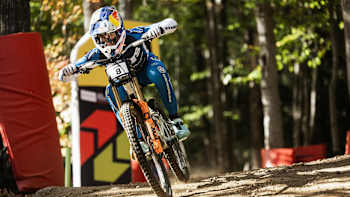Ronan Dunne races downhill at the UCI Mountain Bike World Cup 2025 in Lake Placid, New York, charging through the forest in his Red Bull racing kit for an electrifying run.