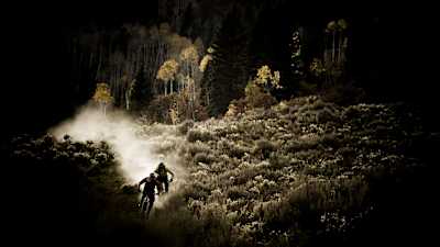 Riders ruedan por un sendero durante la noche.