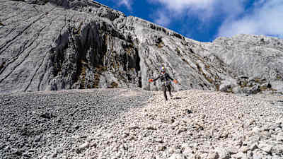 A ultrarrunner brasileira Fernanda Maciel desce um campo de pedras no pico mais alto da Oceania, a Pirâmide Carstensz, também conhecida como Puncak Jaya.