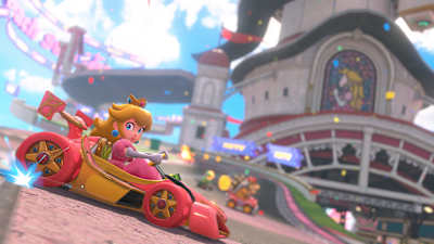 Screenshot aus Mario Kart World zeigt Prinzessin Peach bei einem Drift vor ihrem Schloss.