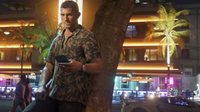 Screenshot aus GTA 6 zeigt Jason Duval an eine Palme lehnend, mit Smartphone in der Hand.