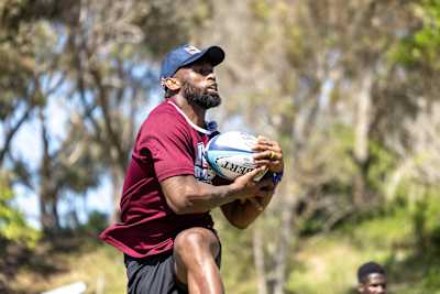 Rugby champion Siya Kolisi catches the ball during training.