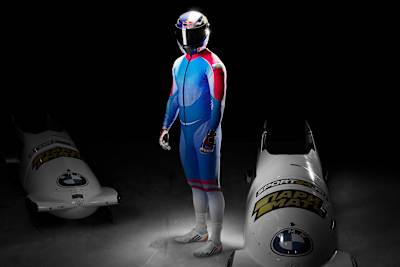 Rostislav Gaitiukevich pose entre deux bobsleighs BMW lors d’une séance d’entraînement.