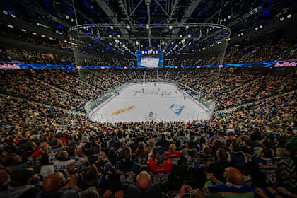 Dans une arène comble, des supporters vibrent au rythme d’un match de hockey sur glace de la NHL.