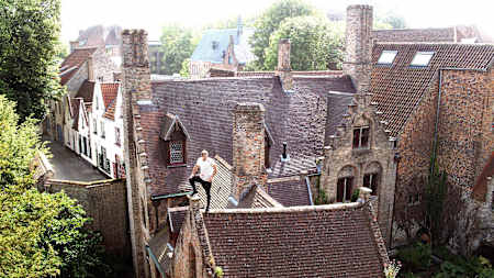 Dominic Di Tommaso stands on a rooftop during the What Tourists Don't See project in Bruges, Belgium