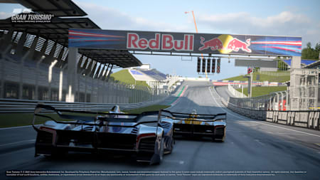 A screenshot of two Red Bull X2014s racing through the Red Bull Ring starting line in the video game Gran Turismo 7.